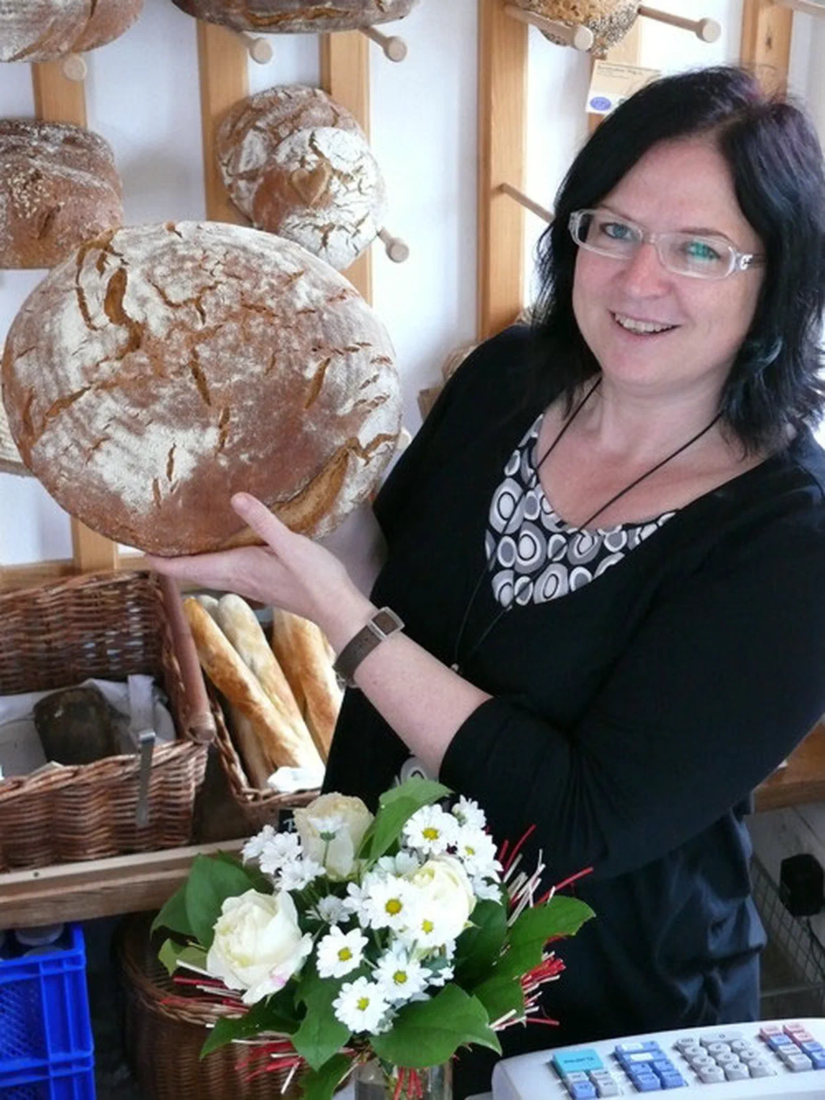 Lucia mit einem frischen Brotlaib im Naturladen